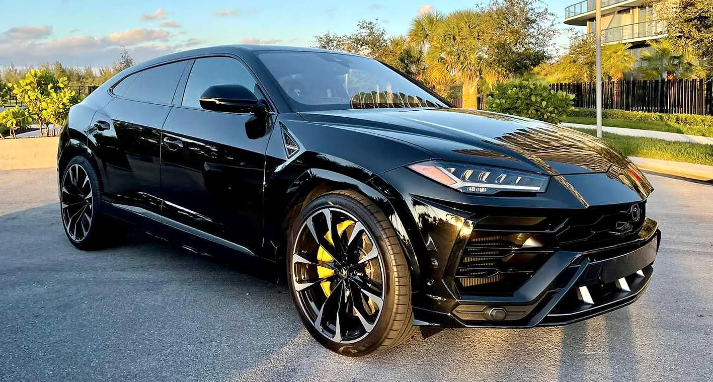 Black Lamborghini Urus in a palm-lined Miami setting